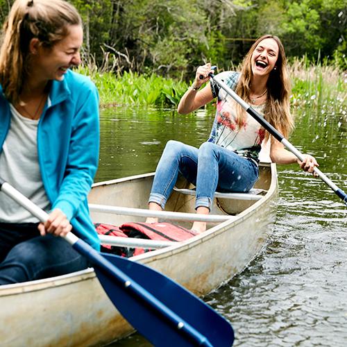 两名威斯康星大学的学生在彭萨科拉校区汤普森河口的独木舟上